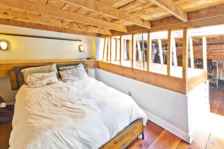 A bedroom with a bed and a wooden ceiling.