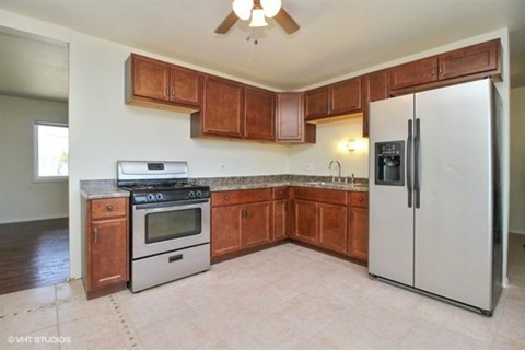 A kitchen with wooden cabinets and a white refrigerator.