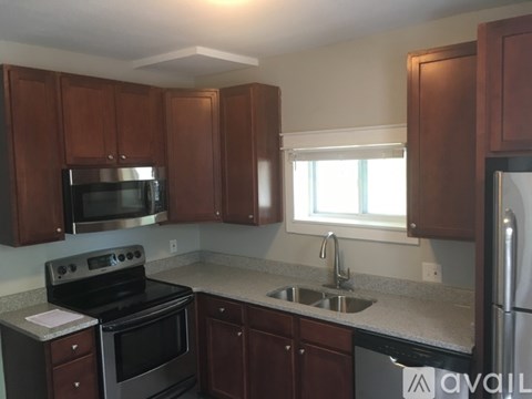 A kitchen with brown cabinets and a stove top oven.