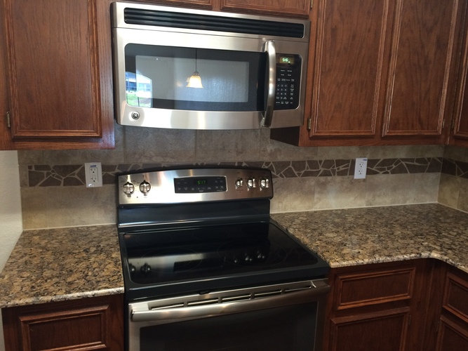 A black microwave oven is installed above a black stove.