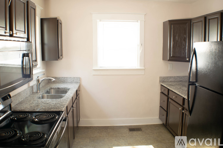A kitchen with a sink, stove, and refrigerator.