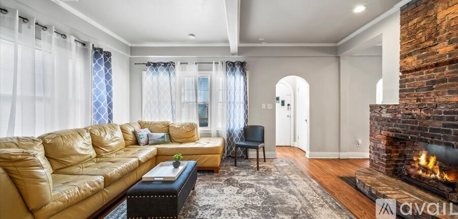 A living room with a leather sofa and a fireplace.