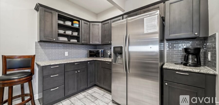 A kitchen with a refrigerator, cabinets, and a counter.