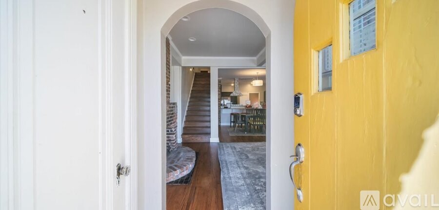 A hallway with a yellow door and a white door on the left.