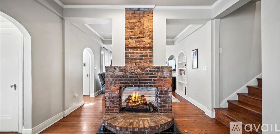 A large open living room with a fireplace and a staircase.