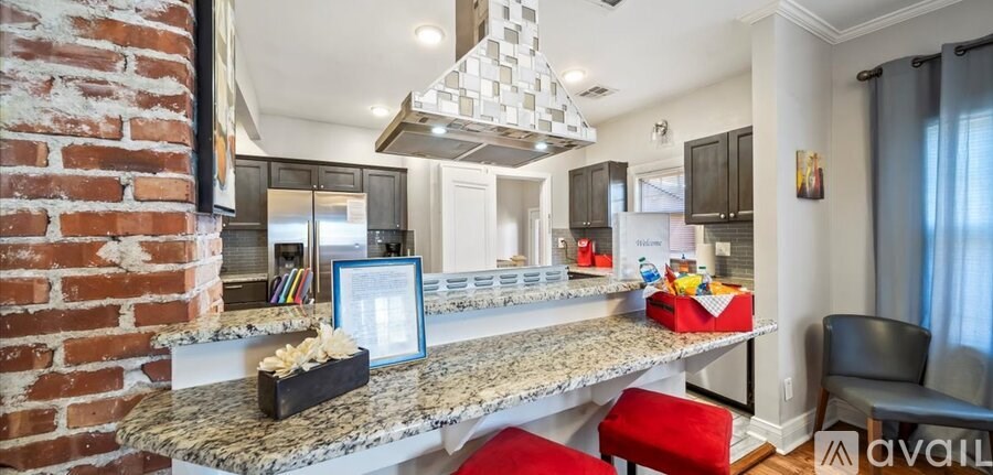A kitchen with a brick wall and a marble countertop.