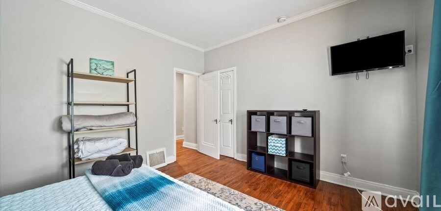 A bedroom with a bunk bed and a TV on the wall.