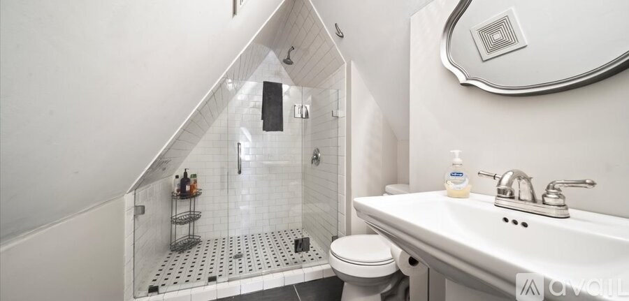 A white sink with a bottle of soap on it.