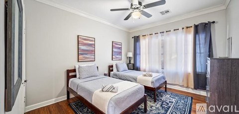 A bedroom with two beds and a ceiling fan.