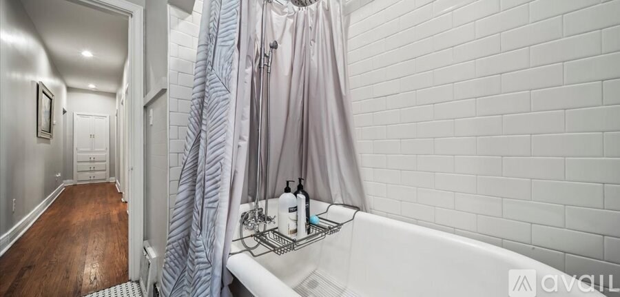 A white bathroom with a white tub and a white shower curtain.