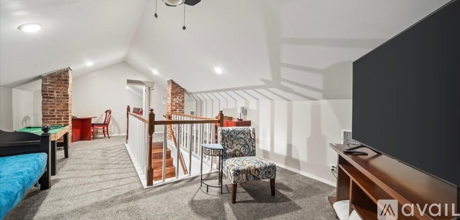 A living room with a blue couch and a pool table.