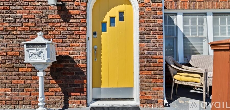 A yellow door is on a red brick building.
