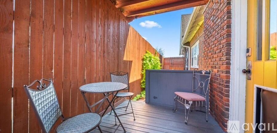 A small balcony with a table and chairs.