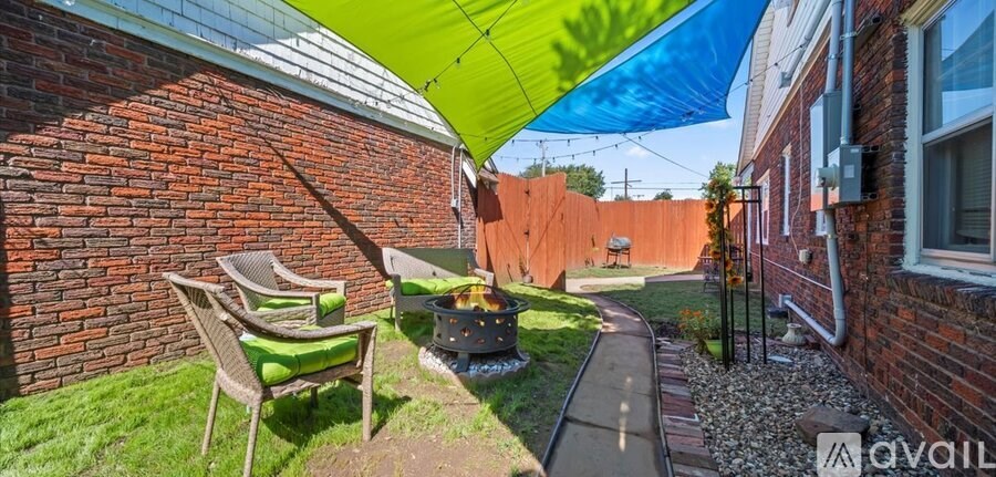 A patio with a table and chairs under a green and blue umbrella.