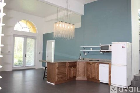 A kitchen with white cabinets and a stove top oven.