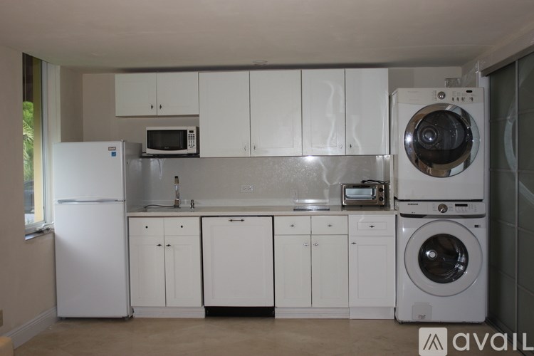 A kitchen with white appliances and cabinets.