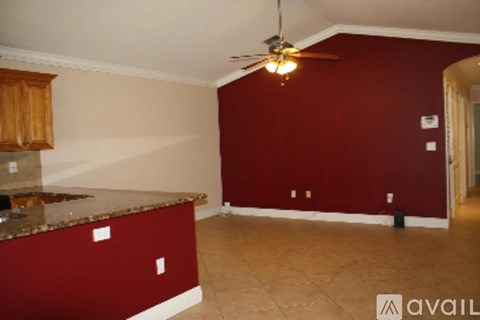 A bedroom with a bed, chair, and rug.