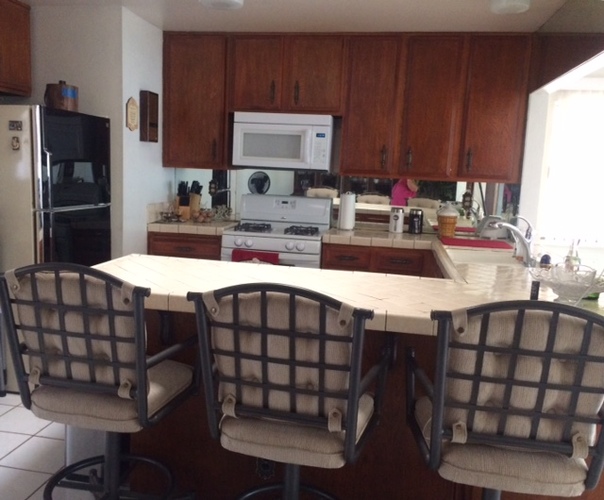 A kitchen with a table and chairs.