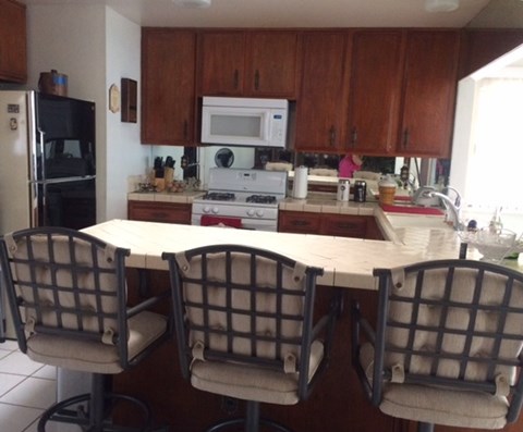 A kitchen with a table and chairs.
