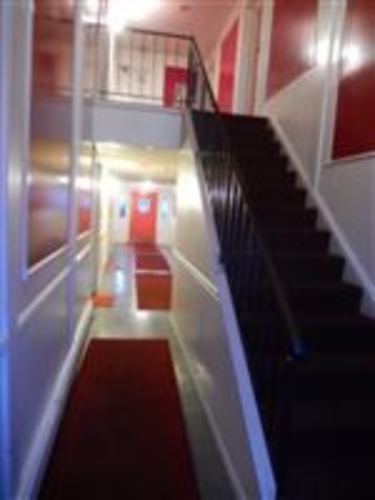 A staircase with a red carpet and a black railing.