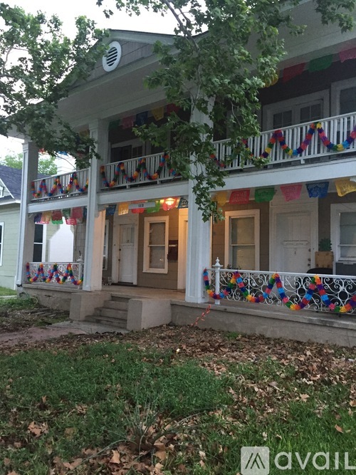 A house with a balcony decorated with colorful flags.