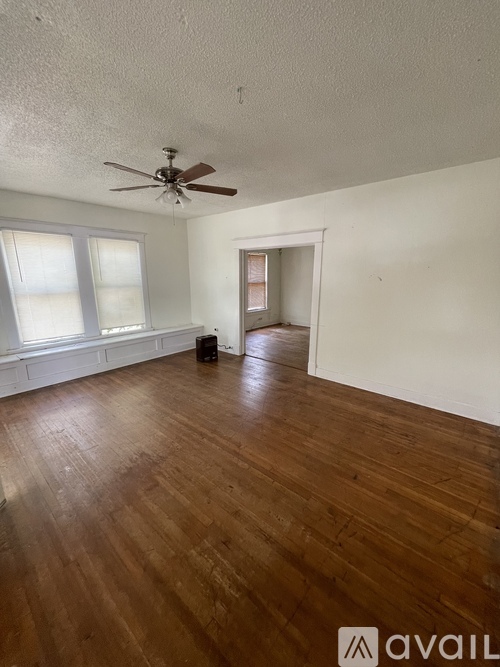 A room with wooden floors and a ceiling fan.