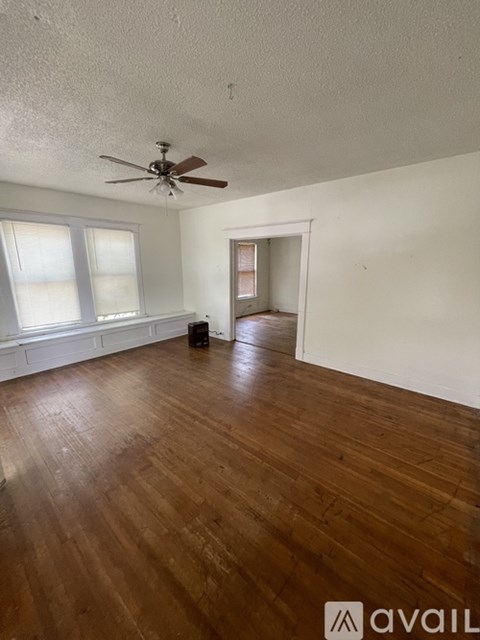 A room with wooden floors and a ceiling fan.