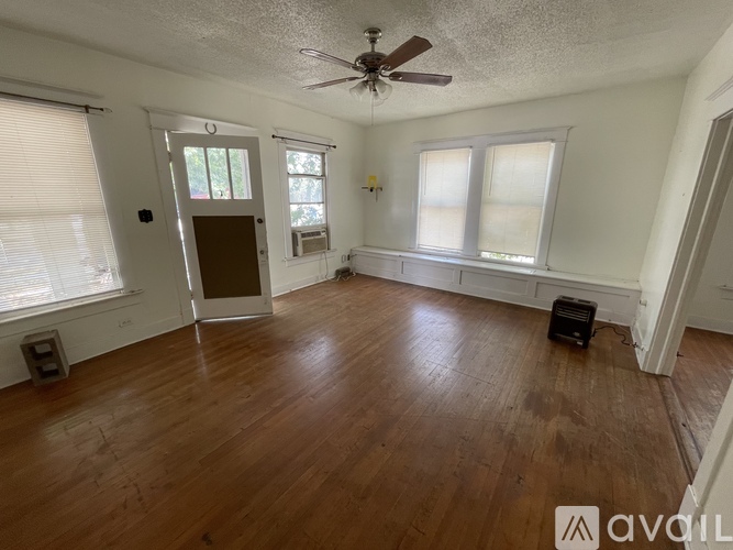 A room with wooden floors and a ceiling fan.