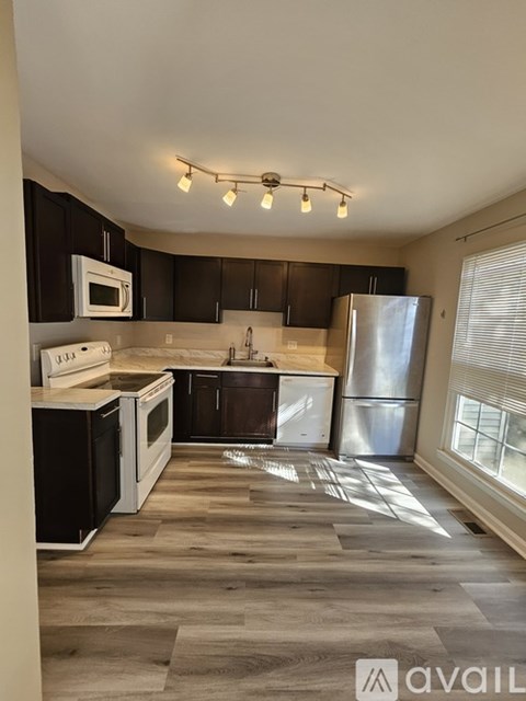 A kitchen with black cabinets and a white fridge.