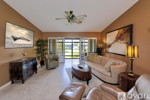 A living room with a couch, chairs, and a painting on the wall.