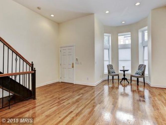 A room with a wooden floor and a staircase.