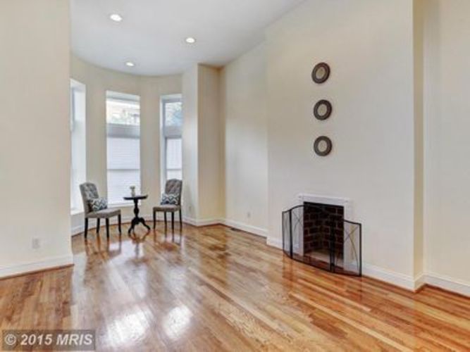 A living room with a fireplace and a table with chairs.