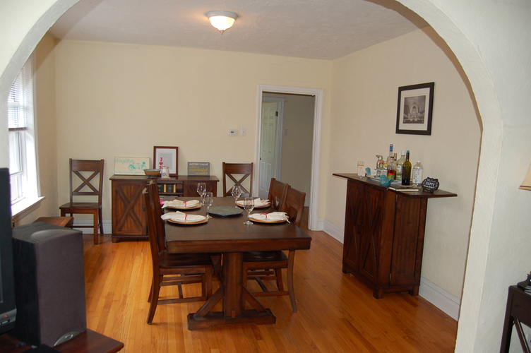 A dining room with a wooden table and chairs.