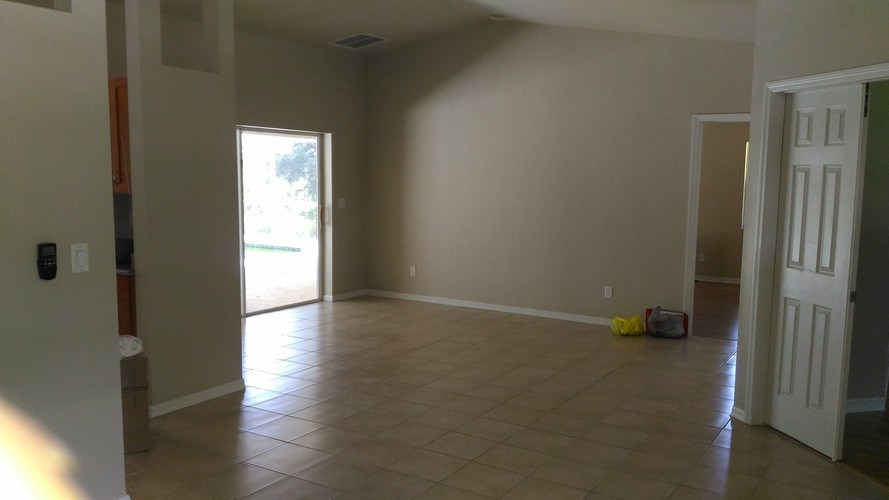 A room with a tile floor and a door leading to another room.
