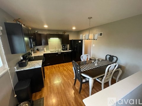 A kitchen with a dining table and chairs.