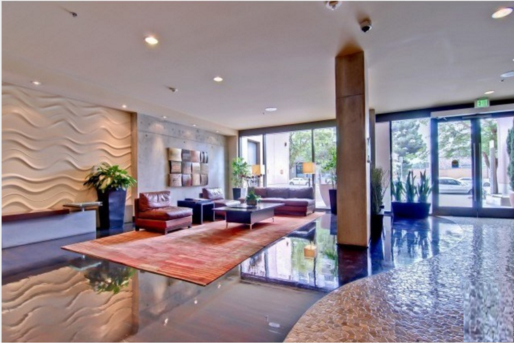 A modern living room with a wooden floor and a large window.