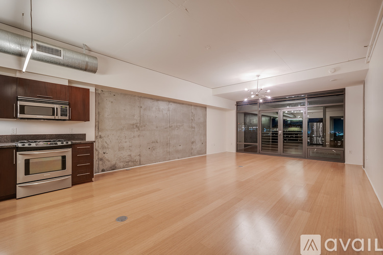A spacious room with wooden flooring and a stainless steel oven.