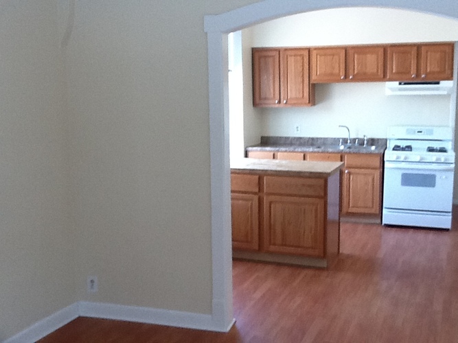 A kitchen with wooden cabinets and a white oven.
