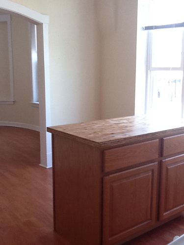 A wooden cabinet with a marble top is in a room.