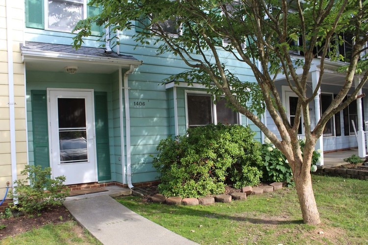 A tree is in front of a house.