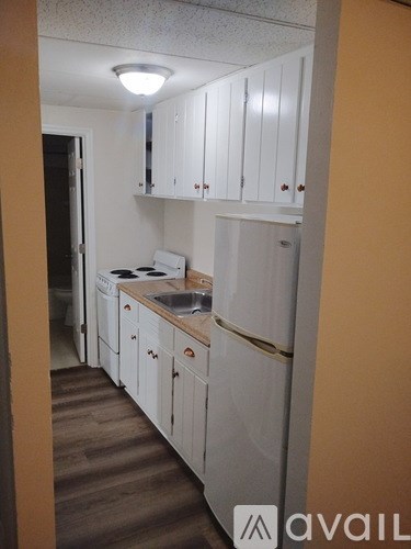 A kitchen with white cabinets and a sink.