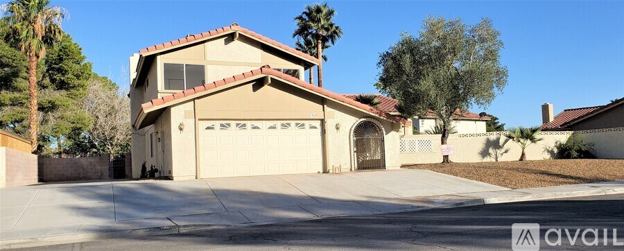 A house with a beige exterior and a red tile roof is for sale.