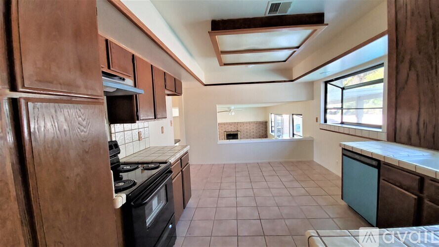 A kitchen with brown cabinets and a black stove top oven.