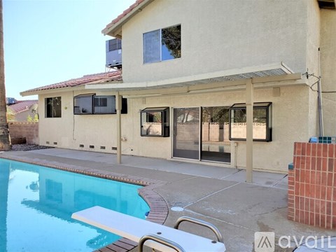 A house with a pool in front of it.