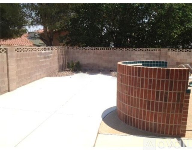 A red brick structure in the middle of a white tiled area.