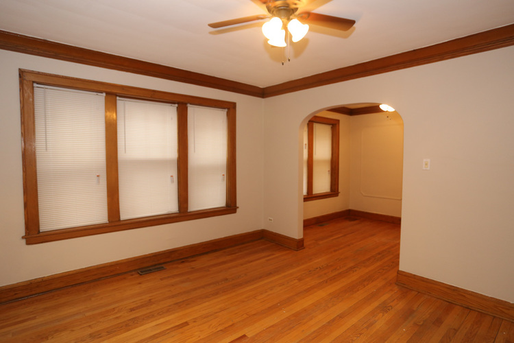 A room with wooden floors and a ceiling fan.