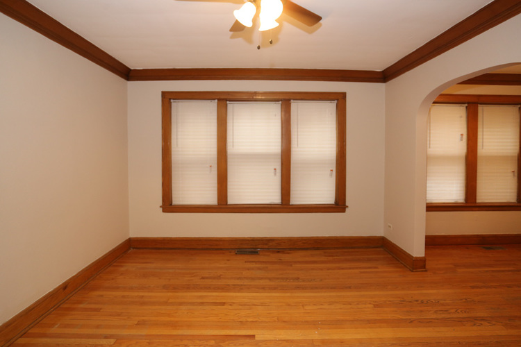 A room with wooden floors and a ceiling fan.