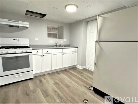 A kitchen with white appliances and cabinets.