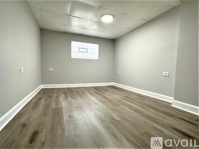 A room with wooden flooring and a window.