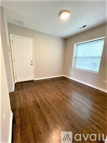 A room with wooden flooring and a window.